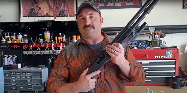 Jeremy Stafford with a Mossberg 500 / 590 series pump-action shotgun.