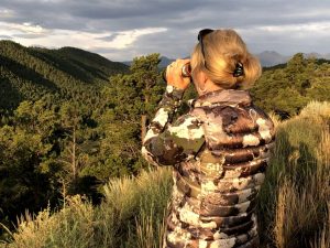 Woman using optics on hillside